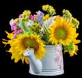 Yellow sunflowers and colored wild flowers in a white sprinkler, close up