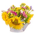 Yellow sunflowers and colored wild flowers in a white sprinkler, close up