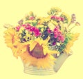 Yellow sunflowers and colored wild flowers in a white sprinkler, close up Royalty Free Stock Photo