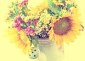 Yellow sunflowers and colored wild flowers in a white sprinkler, close up Royalty Free Stock Photo