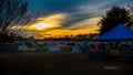 Sunset over a semetary with treeds and tent Royalty Free Stock Photo