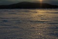 Yellow sunset on the frozen and snow-covered lake. Snow dust Royalty Free Stock Photo