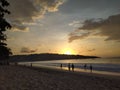 Yellow sunset peek behind hills view from sandy beach