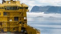 A yellow supply ship at sea heading into deep fog.