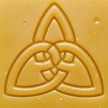Yellow surface featuring a raised Celtic knot design, specifically a trique Royalty Free Stock Photo