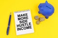 On a yellow surface, a piggy bank, coins and a notepad with the inscription - Make more side hustle income