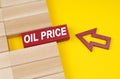 On a yellow surface are wooden blocks and an arrow pointing to a block with the inscription - oil price Royalty Free Stock Photo