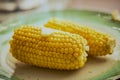Two sweet corn maze cobs on a green plate Royalty Free Stock Photo