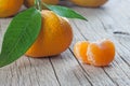 Yellow sweet isolated peeled and whole mandarin clementine tangerine on wooden rustic vintage table with leaf. Tangerines backgrou Royalty Free Stock Photo