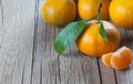 Yellow sweet isolated peeled and whole mandarin clementine tangerine on wooden rustic vintage table with leaf. Tangerines backgrou Royalty Free Stock Photo