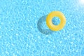 Yellow swimming pool ring float in blue water.