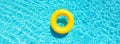 Yellow swimming pool ring float in blue pool water Royalty Free Stock Photo