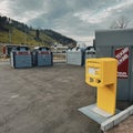Yellow swiss post box and dumpsters for selective garbage collection in Wabern. Royalty Free Stock Photo