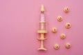 Yellow syringe for applying glaze on confectionery products on pink