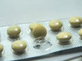 Yellow tablets, film-coated, in plastic packaging