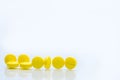 Yellow tablets pills on white background with space