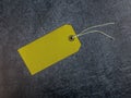 Yellow tag with string on a dark slate background Royalty Free Stock Photo