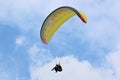 Yellow tandem Paraglider flying in a blue sky Royalty Free Stock Photo