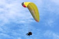 Yellow tandem Paraglider flying in a blue sky Royalty Free Stock Photo