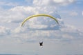 Yellow tandem Paraglider flying in a blue sky Royalty Free Stock Photo