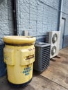Yellow Tank of Used Cooking Oil and Air Conditioning units outside of restaurant
