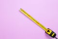 Yellow Tape measure on pastel pink background. Top view and mock up. Building accessories and tool. Copy space Royalty Free Stock Photo