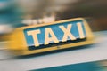 Yellow taxi sign on top of taxi cab. Fast public transport service car on city background