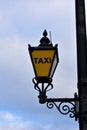 Taxi streetlight with yellow glass and black iron. London, United Kingdom.