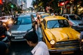 Yellow taxi with traffic jam on the road with a Indian people walking across the road in the evening with lights at Kolkata, India Royalty Free Stock Photo