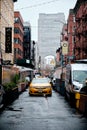 Yellow taxi in the traffic in the street in Little Italy, New York City on a rainy day Royalty Free Stock Photo