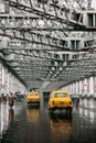 Yellow taxis running on the road inside Howrah Bridge in the afternoon with rain in Kolkata, India