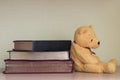 A yellow teddy bear with books