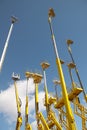 Yellow telescopic cranes under a blue sky Royalty Free Stock Photo