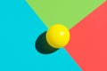 Yellow tennis ball on blue red green triangle elements. Abstract colorful graphic geometric composition. Business innovation