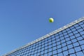 Yellow Tennis Ball Flying Over the Net Royalty Free Stock Photo