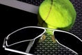 Creative Set Tennis ball, tablet computer and black sunglasses, close-up, on metal background.