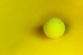 Yellow tennis ball over yellow background. Abstract sport background.