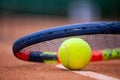 Yellow tennis ball and racket lie on the clay court Royalty Free Stock Photo