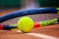 Yellow tennis ball and racket lie on the clay court Royalty Free Stock Photo