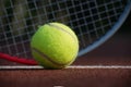 Yellow tennis ball and racquet on hard court surface Royalty Free Stock Photo