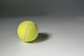 Tennis ball with shadows over grey background