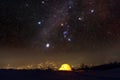 Yellow tent lighted from the inside against the backdrop of glowing city lights Royalty Free Stock Photo