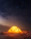 Yellow tent lighted from the inside against the backdrop of glowing city lights Royalty Free Stock Photo