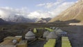 Yellow tents, containers and national yurts of the Basle Camp under Lenin Peak. The amazing nature of Kyrgyzstan