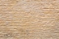 Yellow textured sand background, stone wall with horizontal wavy lines, in close-up Royalty Free Stock Photo