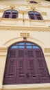 Yellow Thai old style building with old style brown wooden window. Royalty Free Stock Photo