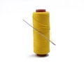 Yellow thread and needle over white