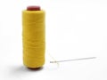 Yellow thread and needle over white