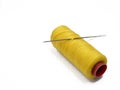 Yellow thread and needle over white