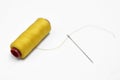 Yellow thread and needle over white